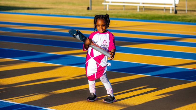 A young girl holding the Baton